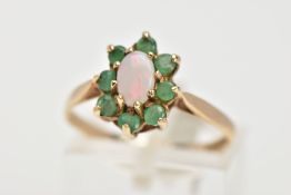 A 9CT GOLD OPAL AND EMERALD CLUSTER RING, the central oval opal cabochon surrounded by claw set