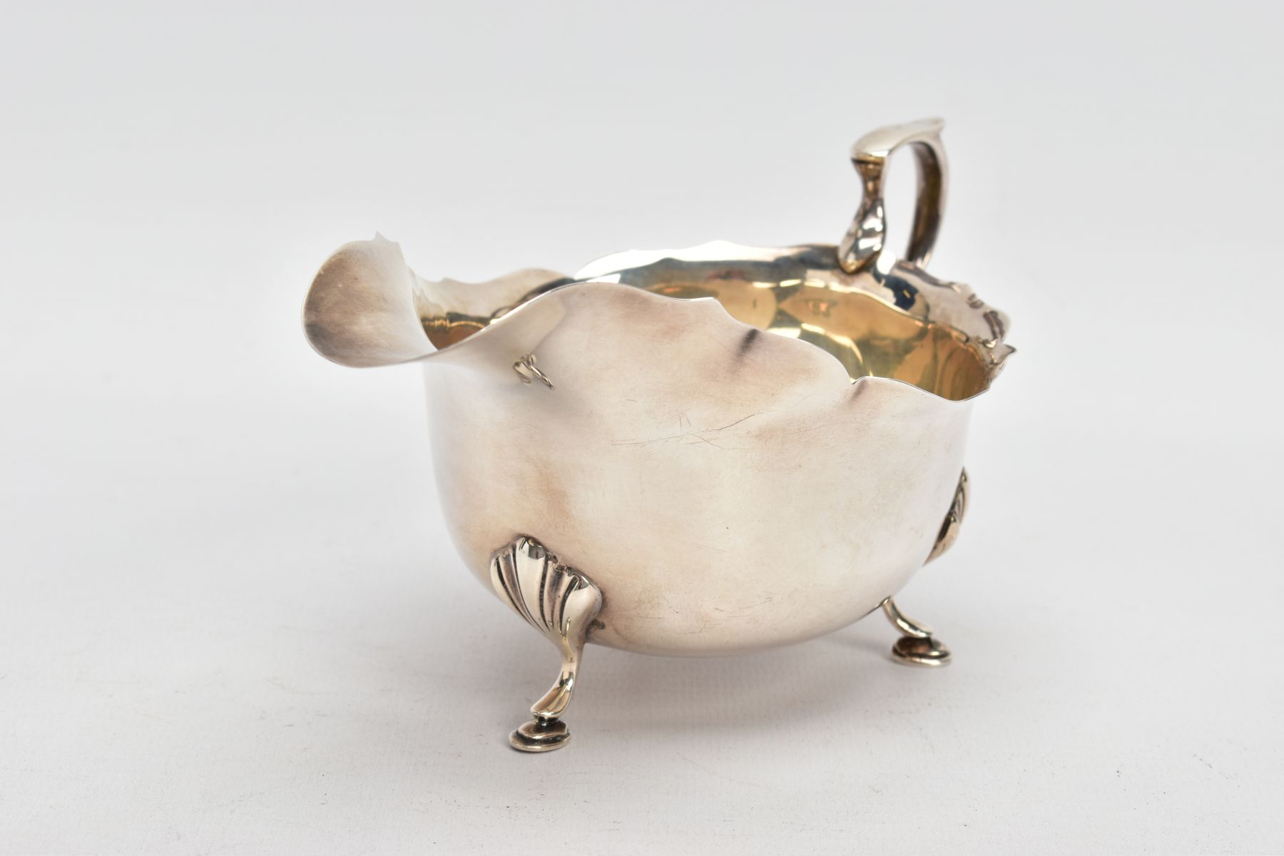 A GEORGE V SILVER GRAVY BOAT, plain polished design, wavy rim, scroll handle, fitted with three hoof - Image 2 of 6