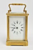 A BRASS CARRIAGE CLOCK, white dial, Roman numerals, blue hands, within a five glass panel