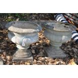 A PAIR OF COMPOSITE BALUSTER GARDEN URNS with fluted detail to sides both 42cm high (some cracks