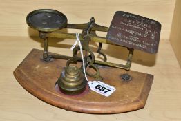 A SET OF POSTAL WEIGHING SCALES WITH A SET OF FIVE WEIGHTS, the gilt metal frame is mounted to a