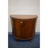 A 20TH CENTURY MAHOGANY DEMI LUNE SINGLE DOOR CABINET, on ball and claw feet, width 110cm x depth