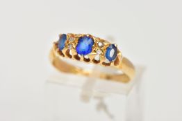 AN EARLY 20TH CENTURY BOAT RING, designed with three oval cut blue stones assessed as garnet and