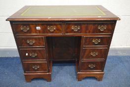 A MAHOGANY KNEE HOLE DESK, the top with a green tooled leather inlay, eight various drawers,