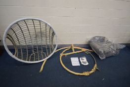A NEARLY NEW RATTAN SINGLE HANGING EGG CHAIR on a circular metal base, width of chair 105cm, with