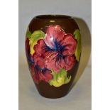 A MOORCROFT POTTERY BALUSTER VASE, red/blue hibiscus on a brown ground, impressed marks to the base,
