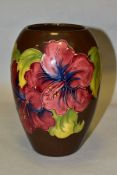 A MOORCROFT POTTERY BALUSTER VASE, red/blue hibiscus on a brown ground, impressed marks to the base,