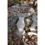 A COMPOSITE BIRD BATH with a spiral flute baluster base and shell shaped bowl 78cm high
