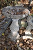 A COMPOSITE BIRD BATH with a spiral flute baluster base and shell shaped bowl 78cm high