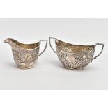 A SILVER CREAMER AND MATCHING SUGAR BOWL, the creamer embossed with a foliate and scroll design with