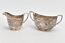 A SILVER CREAMER AND MATCHING SUGAR BOWL, the creamer embossed with a foliate and scroll design with