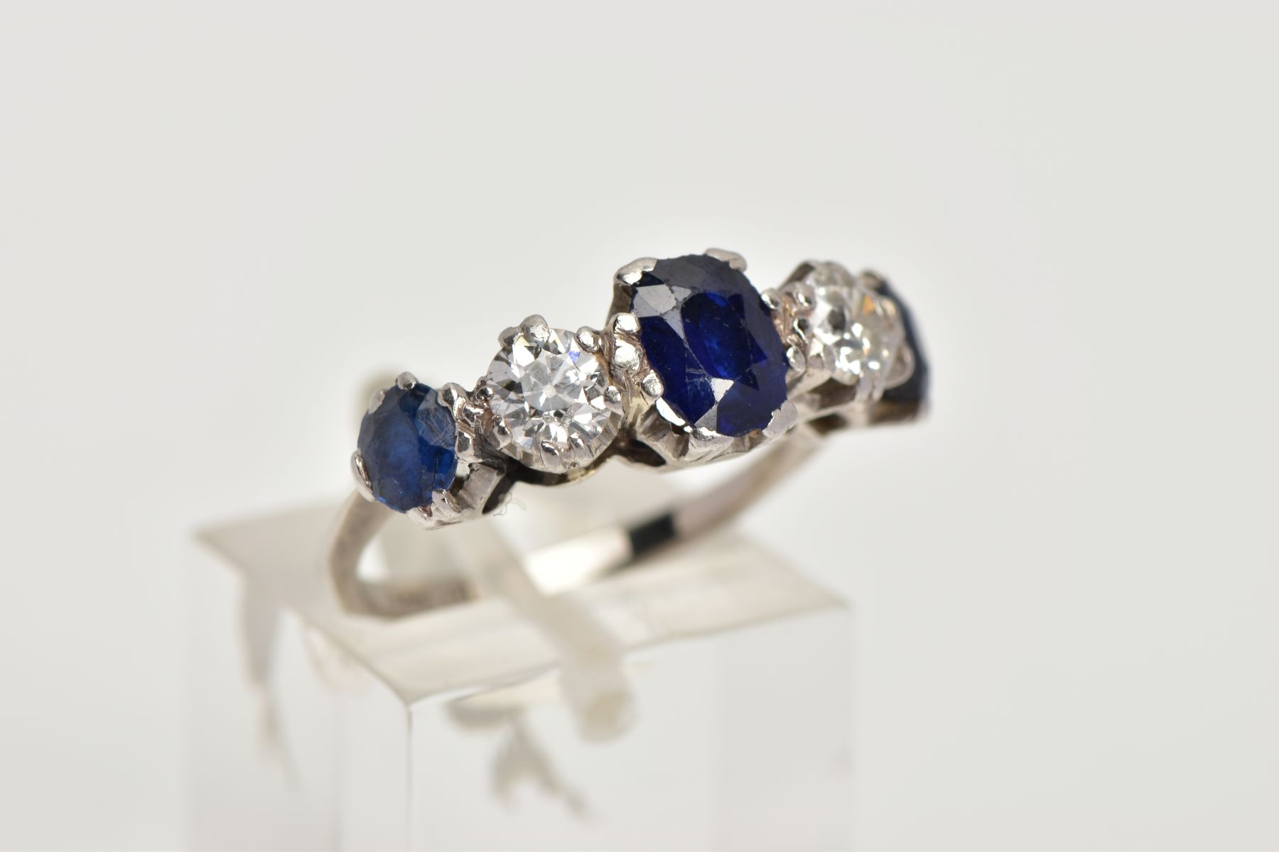 A WHITE METAL DIAMOND AND SAPPHIRE FIVE STONE RING, designed with three four claw set, oval cut blue - Image 4 of 4
