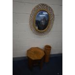 A RATTAN OVAL WALL MIRROR, in the manner of Franco Albini, 67cm x 80cm, along with a wicker umbrella