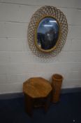 A RATTAN OVAL WALL MIRROR, in the manner of Franco Albini, 67cm x 80cm, along with a wicker umbrella