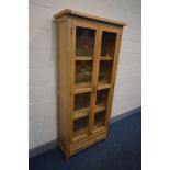 A TALL OAK GLAZED DOUBLE DOOR BOOKCASE with a single drawer, width 86cm x depth 36cm x height 190cm
