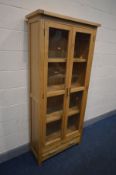 A TALL OAK GLAZED DOUBLE DOOR BOOKCASE with a single drawer, width 86cm x depth 36cm x height 190cm