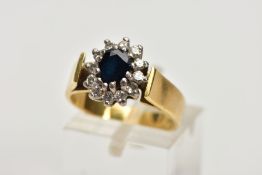 AN 18CT GOLD DIAMOND AND SAPPHIRE CLUSTER RING, centring on an oval cut deep blue sapphire, within a