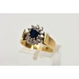 AN 18CT GOLD DIAMOND AND SAPPHIRE CLUSTER RING, centring on an oval cut deep blue sapphire, within a