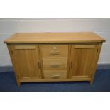 A SOLID OAK SIDEBOARD with two doors flanking three drawers, width 137cm x depth 47cm x 85cm (