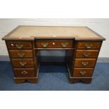AN EDWARDIAN MAHOGANY AND BOX STRUNG INLAID INVERTED BREAKFRONT KNEEHOLE DESK, with a brown