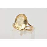 A YELLOW METAL CITRINE RING, designed with a twelve claw set, oval cut citrine, measuring