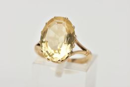 A YELLOW METAL CITRINE RING, designed with a twelve claw set, oval cut citrine, measuring