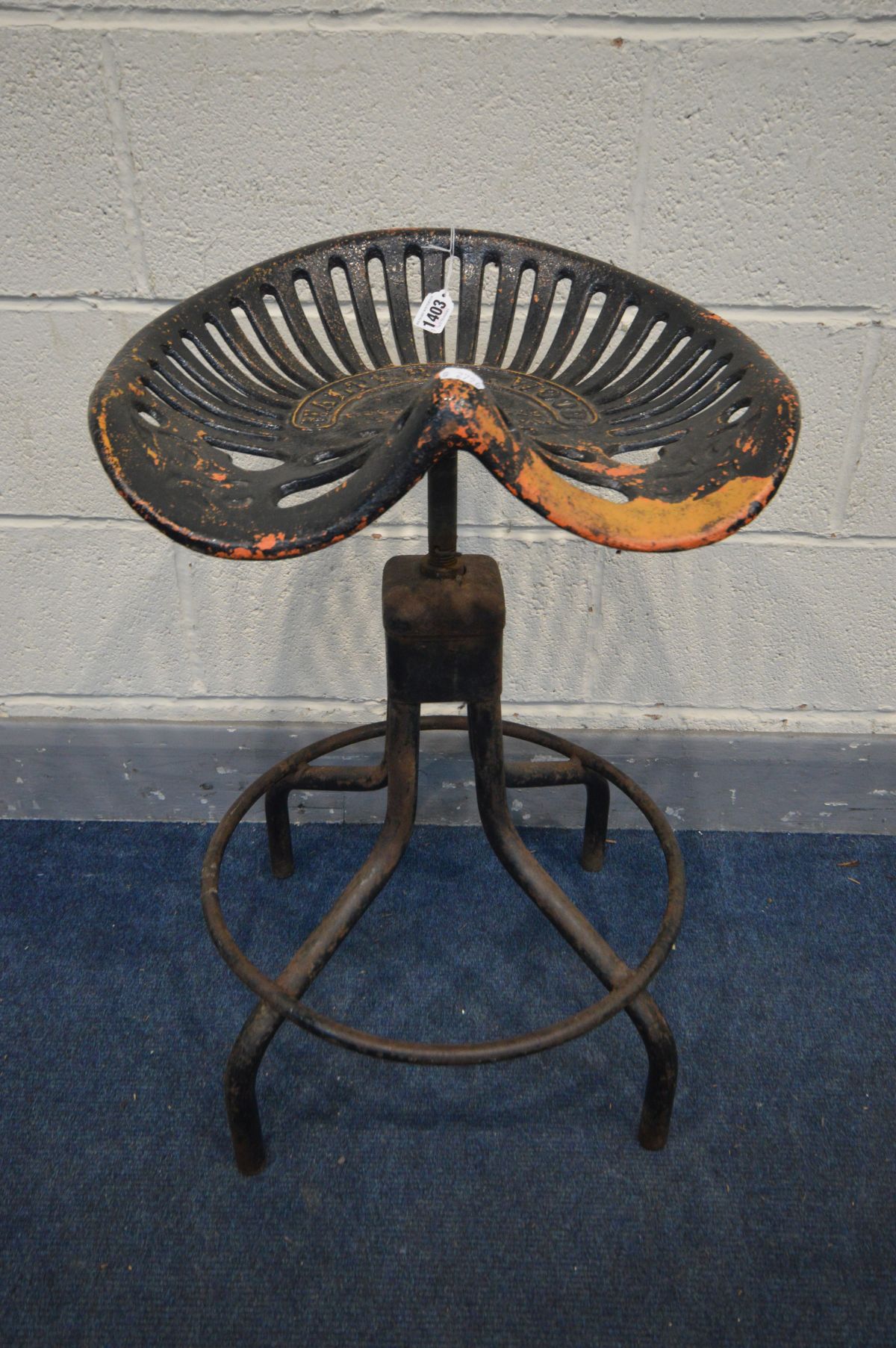 A METAL SWIVEL STOOL, the tractor seat marked Walter A Wood, on a matched tubular base, height 71cm