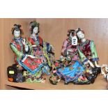 FOUR SECOND HALF 20TH CENTURY JAPANESE POTTERY FIGURES OF SEATED LADIES, florally encrusted and