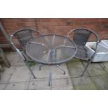 A CIRCULAR METAL FRAMED GARDEN TABLE, with a glass top, diameter 61cm together with two matching