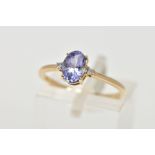 A 9CT GOLD TANZANITE AND DIAMOND RING, designed with a four claw set, oval cut tanzanite, flanked