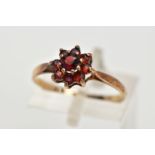 A 9CT GOLD GARNET CLUSTER RING, set with circular cut garnets, tapered shoulders, hallmarked 9ct
