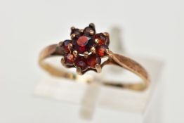 A 9CT GOLD GARNET CLUSTER RING, set with circular cut garnets, tapered shoulders, hallmarked 9ct