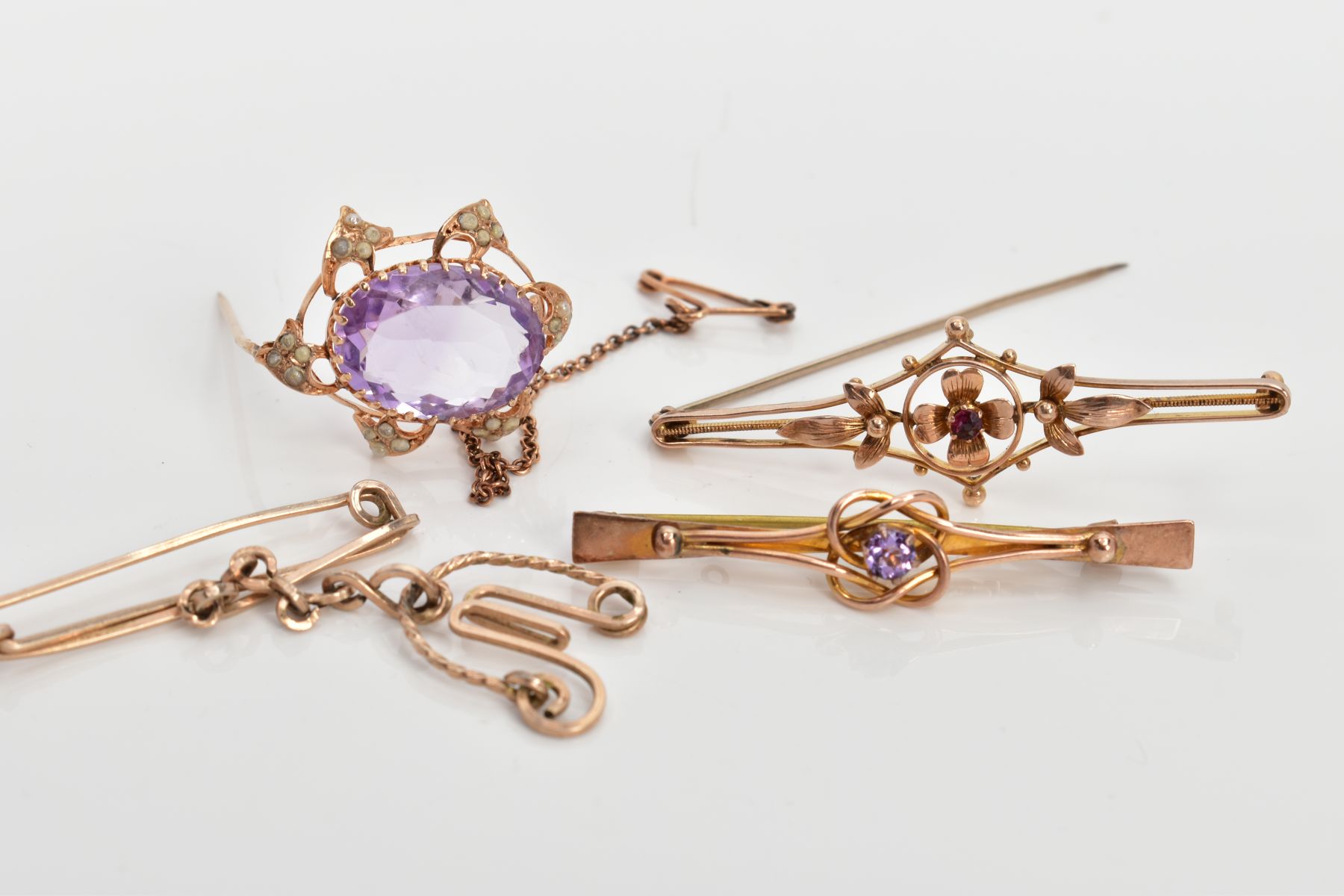 FOUR YELLOW METAL BROOCHES, to include an openwork floral bar brooch, set with a central small