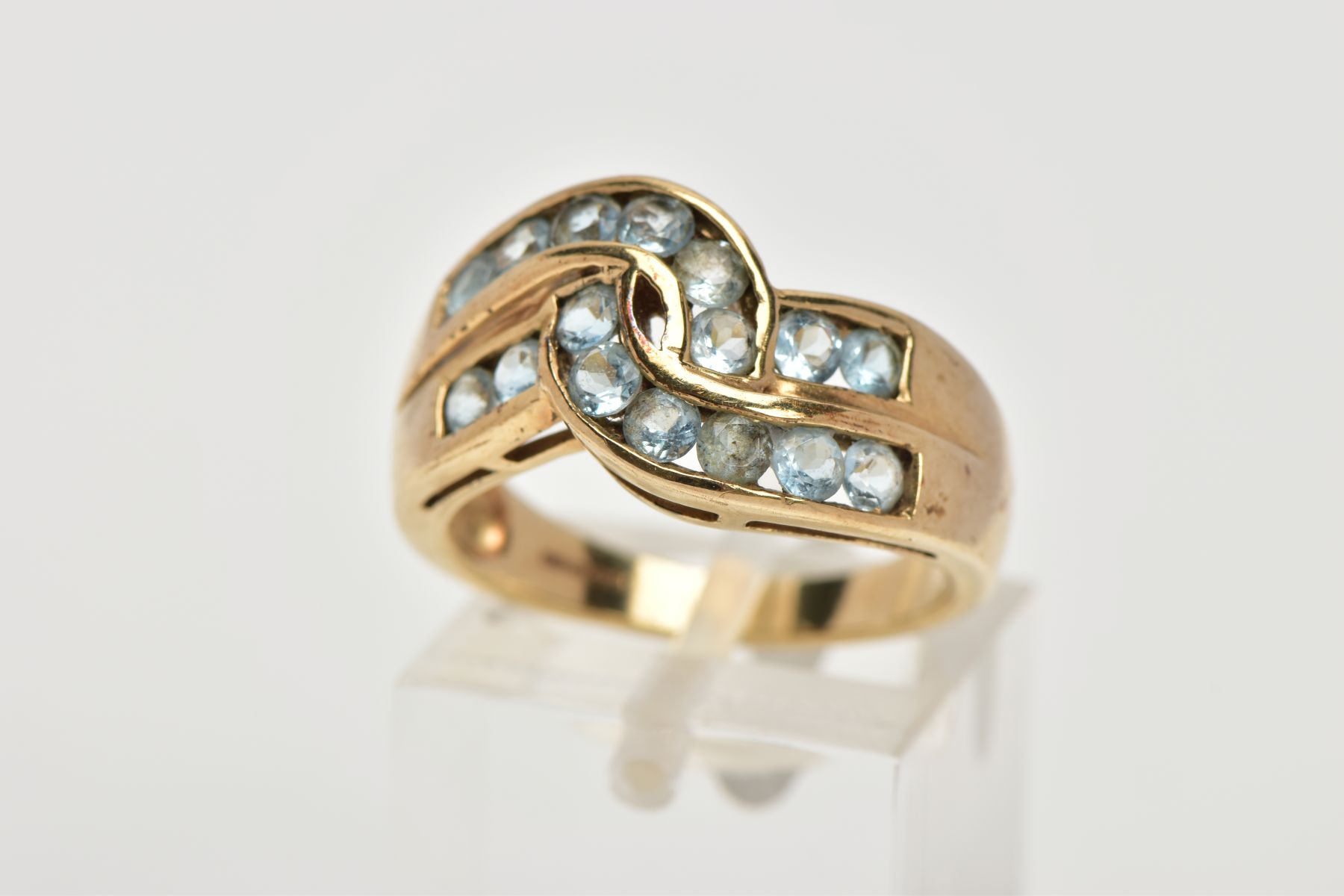 A 9CT GOLD AQUAMARINE DRESS RING, of a cross over style, set with two rows of circular cut