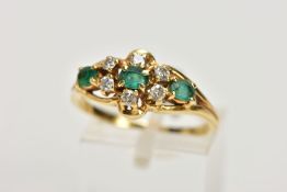 AN EMERALD AND DIAMOND RING, designed as a central oval emerald, surrounded by six round brilliant