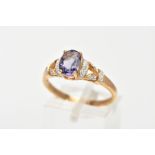 A 9CT GOLD AMETHYST AND DIAMOND RING, designed with a central, four claw set oval cut amethyst