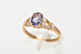 A 9CT GOLD AMETHYST AND DIAMOND RING, designed with a central, four claw set oval cut amethyst