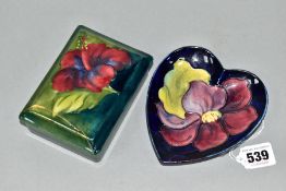 A MOORCROFT POTTERY HEART SHAPED PIN DISH IN THE CLEMATIS PATTERN, on a dark blue ground, paper