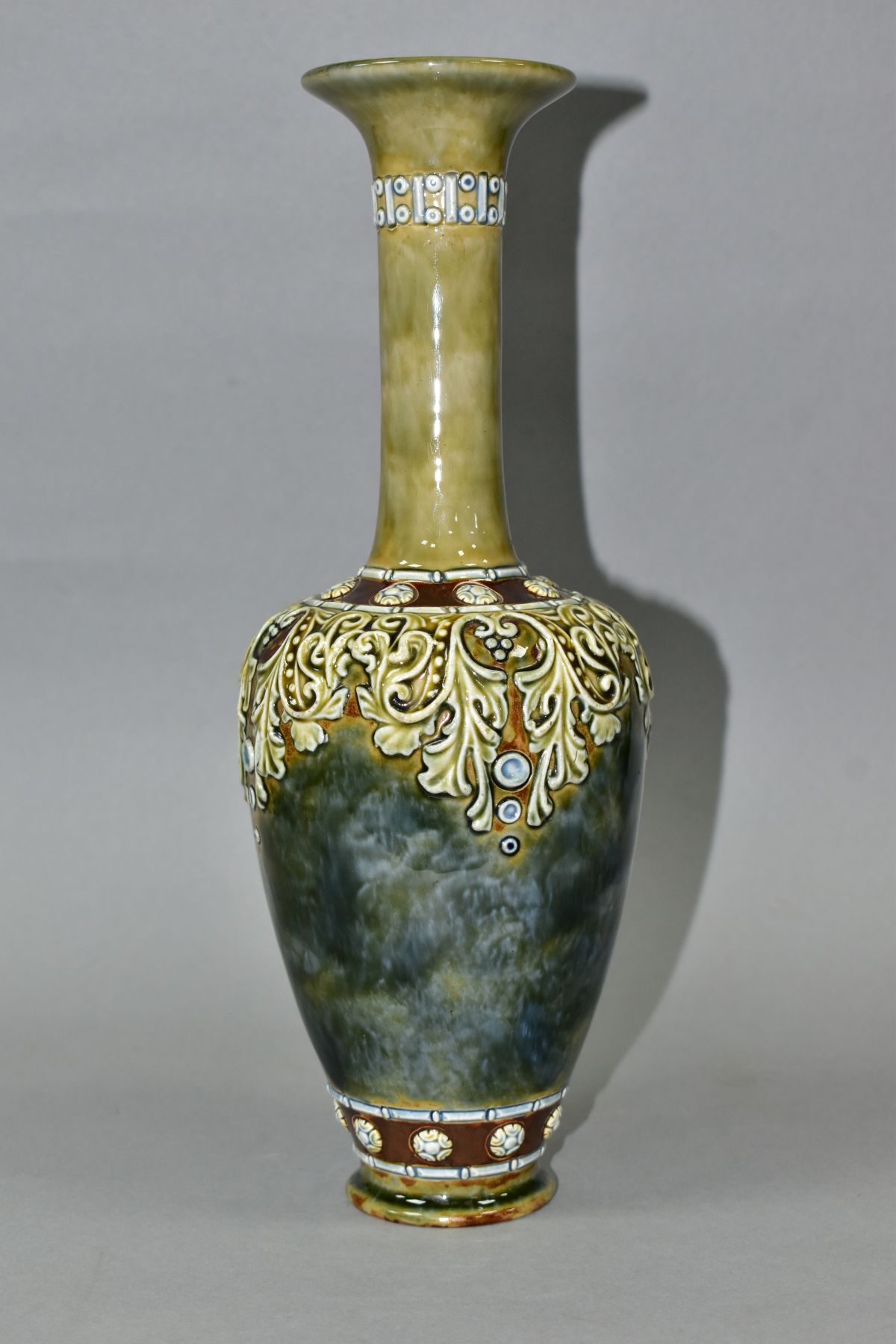 A ROYAL DOULTON STONEWARE BALUSTER VASE, mottled blue/green glaze with relief decorated foliate