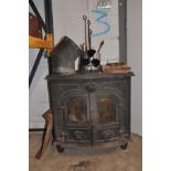 A CAST IRON LOG BURNER with two glazed doors, two water inlets and two outlets to rear, flues,