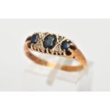 A 9CT GOLD SAPPHIRE AND DIAMOND RING, designed with three graduated oval cut blue sapphires,