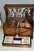 AN OAK CASED MIRROR BACKED TANTALUS WITH GAMING DRAWER AND DRINKING GLASS STORAGE COMPARTMENT to