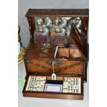 AN OAK CASED MIRROR BACKED TANTALUS WITH GAMING DRAWER AND DRINKING GLASS STORAGE COMPARTMENT to