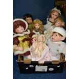 A BOX OF COLLECTORS DOLLS, to include seven dolls, a heavy porcelain soft bodied baby doll marked