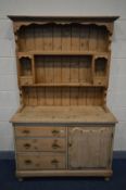 A VICTORIAN PINE DRESSER, with a later top, the base with three drawers besides a cupboard doors,