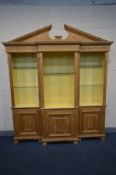 A PINE BREAKFRONT OPEN THREE SECTION BOOKCASE, swan neck pediment, later painted interior and
