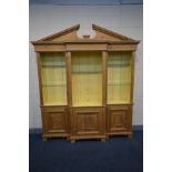 A PINE BREAKFRONT OPEN THREE SECTION BOOKCASE, swan neck pediment, later painted interior and