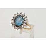 A 9CT GOLD TOPAZ CLUSTER RING, designed with a central oval cut blue topaz, within a surround of