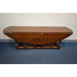 A REPRODUCTION OAK OVAL TOP WAKE TABLE, with double gate legs, on turned and block legs, united by