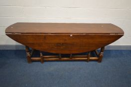 A REPRODUCTION OAK OVAL TOP WAKE TABLE, with double gate legs, on turned and block legs, united by